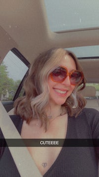 a woman wearing sunglasses in the back seat of a car