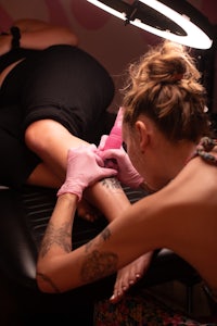 a woman getting a tattoo on her leg