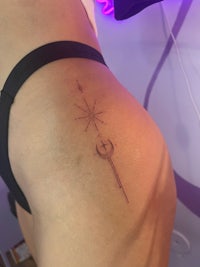 a woman's thigh tattoo with a star and arrow