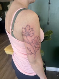 a woman with a flower tattoo on her arm