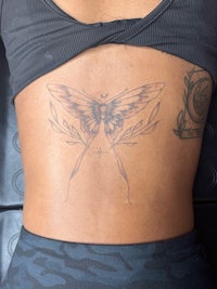 a woman with a butterfly tattoo on her back